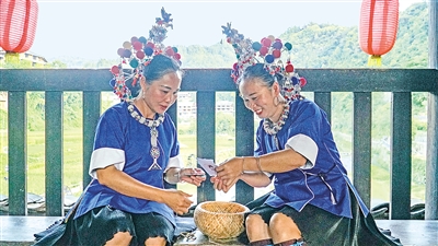     程陽橋上，侗族婦女在展示制作侗族刺繡產(chǎn)品。繡品圖案精美、色彩艷麗，成為當?shù)靥厣a(chǎn)業(yè)。